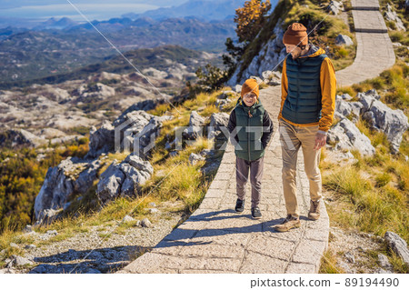 Dad and son travellers in mountain landscape at national park Lovcen, Montenegro. Travel to Montenegro with children concept 89194490