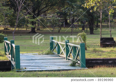 Dark green painted wood bridge in garden. Dark green painted wood bridge in garden. 89196960