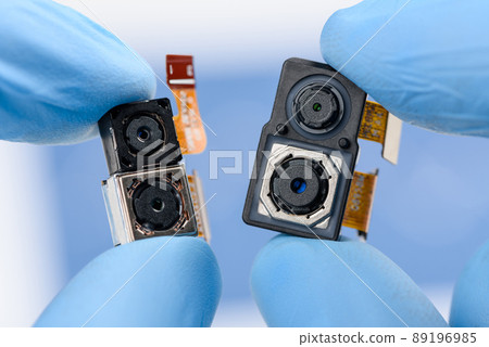 Smartphone single and dual camera modules in scientist hands. Different sensor sizes and technology 89196985
