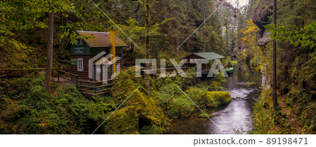 entrance (cabin, shed and boat) to the river port by the river flowing through rocky ravine in Bohemian Switzerland, The Kamnitz Gorge, Czech Republic 89198471
