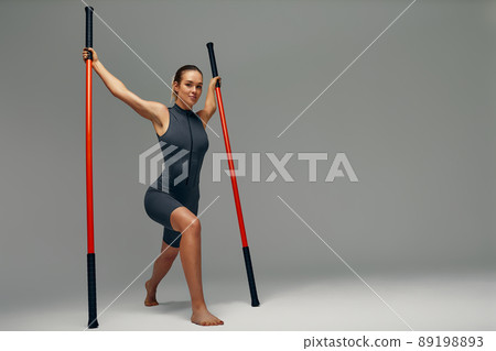 beautiful girl in sports uniform is training kung fu in the studio, fighter athlete, practicing martial arts with a stick beautiful girl in sports uniform is training kung fu in the studio, fighter athlete, practicing martial arts with a stick 89198893