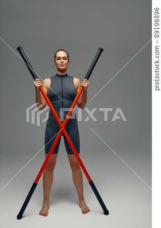 beautiful girl in sports uniform is training kung fu in the studio, fighter athlete, practicing martial arts with a stick 89198896