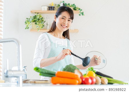 Smiley middle woman cooking in the kitchen 89198922