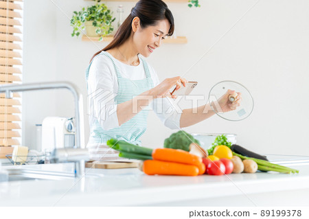 Smiley middle woman cooking in the kitchen 89199378
