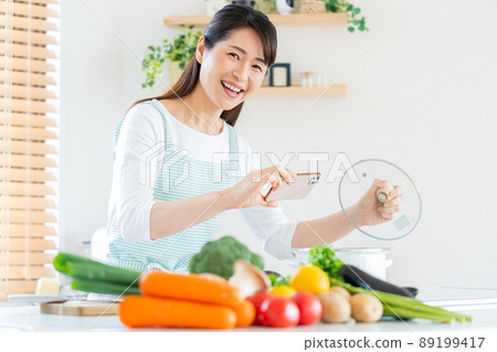 Smiley middle woman cooking in the kitchen 89199417