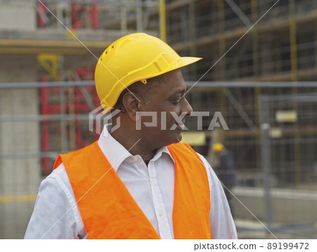 Profile portrait of a smiling civil engineer or factory worker wearing a safety helmet and looking aside 89199472