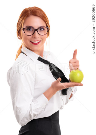 Young businesswoman holding apple and raising thumb up Young businesswoman holding apple and raising thumb up 89200669