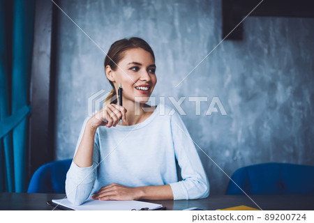 Happy woman with pen in workspace 89200724