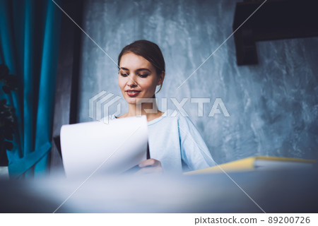 Concentrated woman with sheet of paper in room 89200726