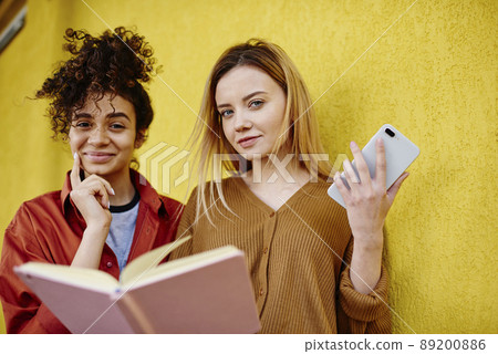 Positive woman with notebook looking at camera 89200886