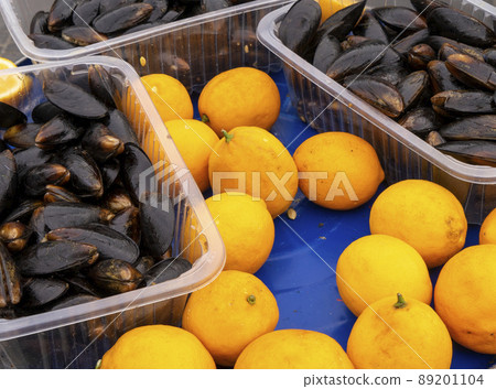 Mussels in the shell with lemon on blue iron background. Mussels in the shell with lemon on blue iron background. 89201104