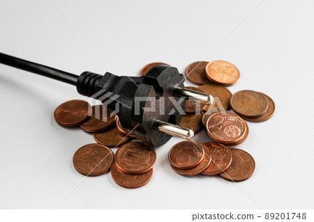 Black plug on coins and white background,cost of electricity and expensive energy concept Black plug on coins and white background,cost of electricity and expensive energy concept 89201748