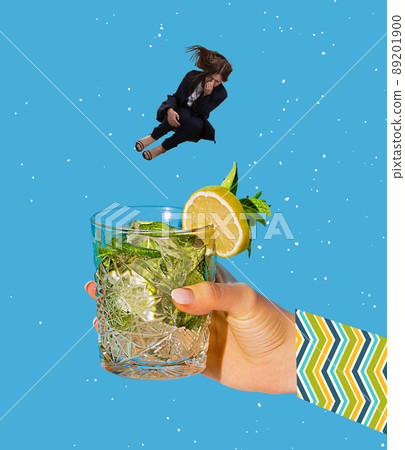Contemporary art collage. Young woman jumping into cocktail, mojito isolated over blue background 89201900