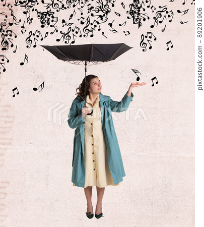Contemporary art collage of beautiful woman in rain coat standing with umbrella under falling music notes isolated over grey background Contemporary art collage of beautiful woman in rain coat standing with umbrella under falling music notes isolated over grey background 89201906