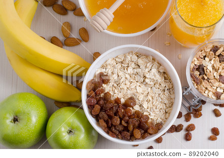 Bowl of oatmeal and raisins. Honey, bananas, green apples, nuts 89202040