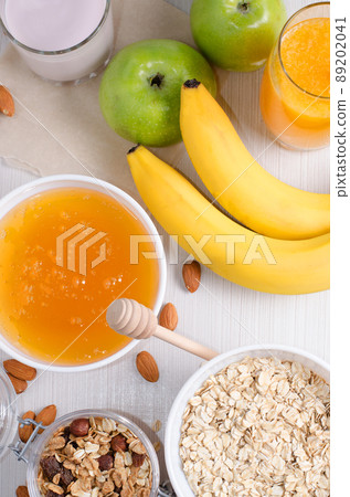 Bowl of oatmeal and raisins. Honey, bananas, green apples, nuts. Flat lay Bowl of oatmeal and raisins. Honey, bananas, green apples, nuts. Flat lay 89202041