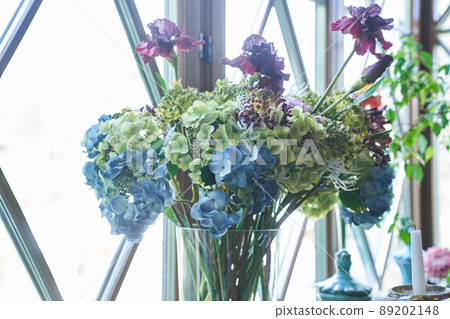 Beautiful blue hydrangea flowers in a glass vase on the background of the window.Beautiful bouquet of flowers in a vase on the windowsill indoors. High quality photo Beautiful blue hydrangea flowers in a glass vase on the background of the window.Beautiful bouquet of flowers in a vase on the windowsill indoors. High quality photo 89202148