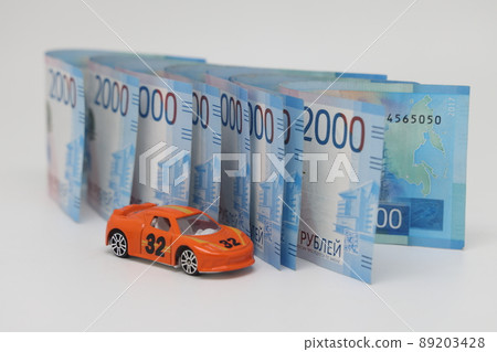 Toy car on the background of banknotes, purchase, insurance and the cost of car ownership. 89203428