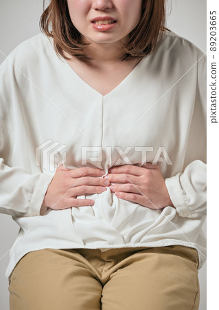 一個有胃痛并且可以握住她的手的年輕女人 89203665