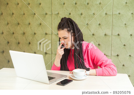 You are liar. Young freelancer woman with black dreadlocks hairstyle in pink blouse is sitting and making video call on laptop, talking and pointing finger to nose to showinn lie gesture. indoor You are liar. Young freelancer woman with black dreadlocks hairstyle in pink blouse is sitting and making video call on laptop, talking and pointing finger to nose to showinn lie gesture. indoor 89205076