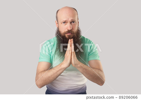 Please help me, forgive me or give me one chance more. Portrait of pleased middle aged bald bearded man standing with palm hands, looking and begging. indoor studio shot, isolated on grey background. Please help me, forgive me or give me one chance more. Portrait of pleased middle aged bald bearded man standing with palm hands, looking and begging. indoor studio shot, isolated on grey background. 89206066