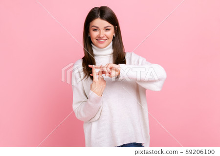 Positive popular woman blogger making hashtag sign with fingers, tagging posts in social networks, wearing white casual style sweater. Indoor studio shot isolated on pink background. Positive popular woman blogger making hashtag sign with fingers, tagging posts in social networks, wearing white casual style sweater. Indoor studio shot isolated on pink background. 89206100