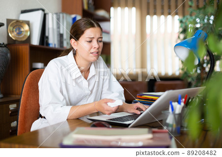 Frustrated girl in the office works at the computer 89208482