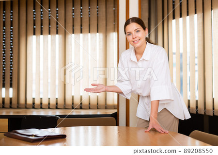 Friendly woman businessman invites to office Friendly woman businessman invites to office 89208550