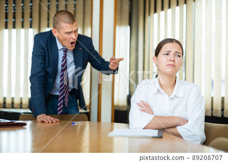 Emotional young boss berates his secretary girl in the conference room 89208707