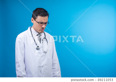 Discontented doctor with stethoscope standing in studio 89211053