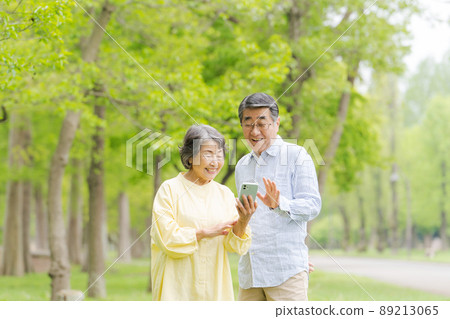 Senior men and women park with smartphones 89213065