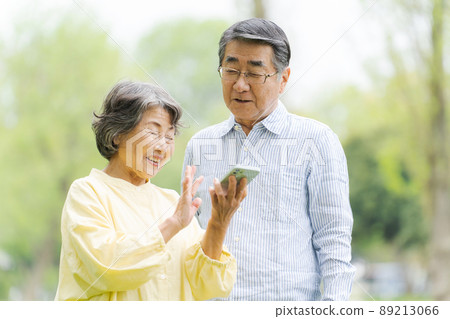 在戶外使用智能手機的高級男女 89213066