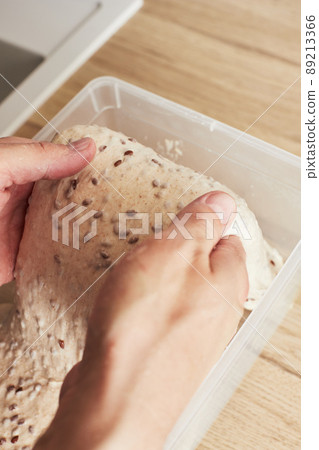 Making homemade wheat bread with flax seeds. The dough rinsing. The concept of homemade bread and healthy food. Vertical photo. Making homemade wheat bread with flax seeds. The dough rinsing. The concept of homemade bread and healthy food. Vertical photo. 89213366