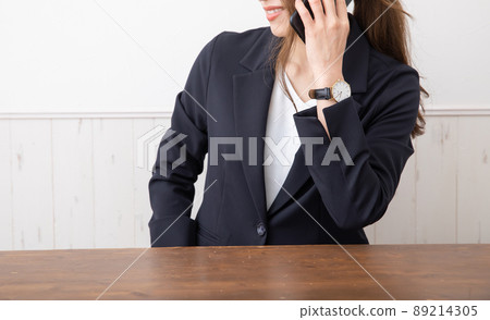 A woman in a suit talking on a mobile phone business 89214305