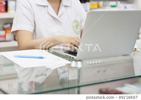 Pharmacist with laptop computer and medication in the pharmacy 89216687