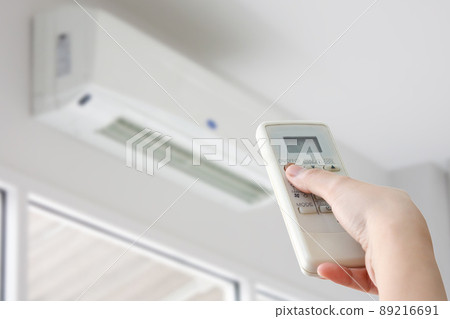 Hand with remote control directed on air conditioner 89216691