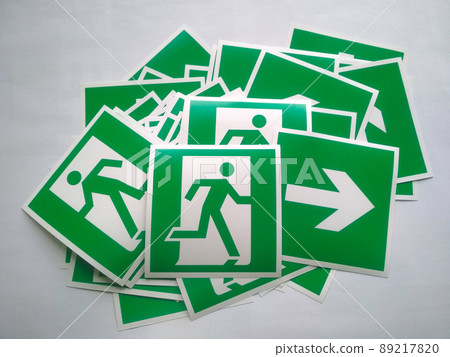Fire exit sign or Sign fire escape. Pile of evacuation arrow stickers. White symbol on green background. Emergency arrow warning for safety to run exit of building. Fire exit sign or Sign fire escape. Pile of evacuation arrow stickers. White symbol on green background. Emergency arrow warning for safety to run exit of building. 89217820