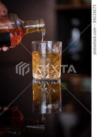 Whiskey pouring into a glass alcohol Whiskey pouring into a glass alcohol 89219273