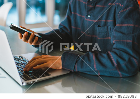 Young men and laptops and smartphones 89219388