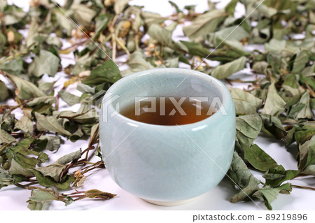 Houttuynia cordata tea in a bowl and dried Houttuynia cordata leaves 89219896