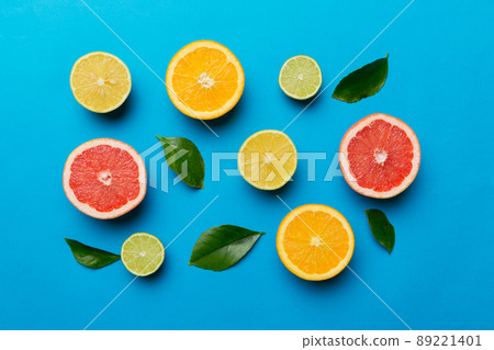 Flat lay of citrus fruits like lime, orange and lemon with lemon tree leaves on light colored background. Space for text healthy concept. Top view 89221401