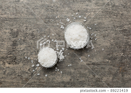 A wooden bowl of salt crystals on a wooden background. Salt in rustic bowls, top view with copy space A wooden bowl of salt crystals on a wooden background. Salt in rustic bowls, top view with copy space 89221419