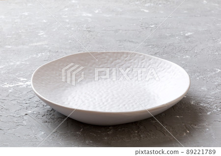 Perspective view of empty light plate on cement background. Empty space for your design 89221789