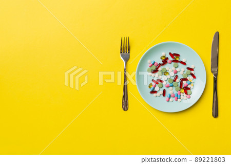 Many different weight loss pills and supplements as food on round plate. Pills served as a healthy meal. Drugs, pharmacy, medicine or medical healthycare concept 89221803