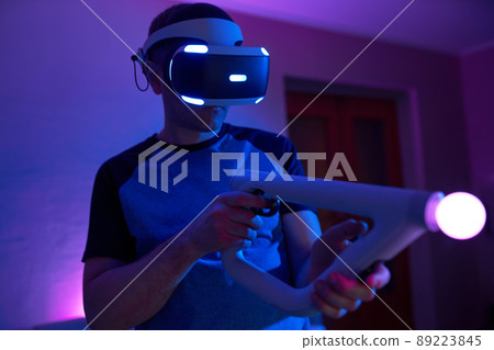 Man with virtual reality headset and joystic is playing game Man with virtual reality headset and joystic is playing game 89223845