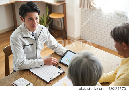 Elderly couple talking to a man in work clothes 89224270