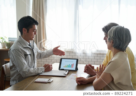 Elderly couple talking to a man in work clothes 89224271