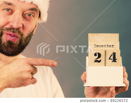 December 24th. Man santa hat holds calender December 24th. Man santa hat holds calender 89226572