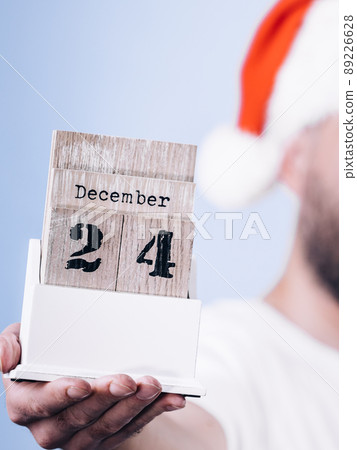 December 24th. Man santa hat holds calender 89226628