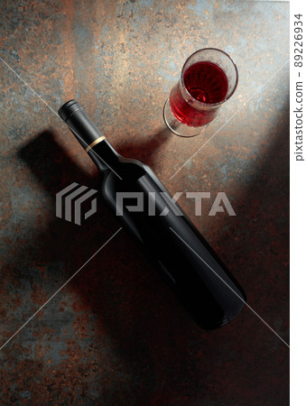 Glass and bottle of red wine on a rusty metal background. 89226934